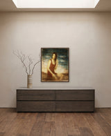 Envisioning the Past by Frantisek Strouhal: a woman in a red dress seated, hand at her hair, teal sky, the 24 by 30 inch print in a dark oak floater frame, hanging above a smoked ash sideboard in a calm room, shown at its true size