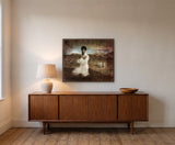 My Freedom by Frantisek Strouhal: a man in a white shirt with arms crossed, brown hills and small figures behind, the 30 by 24 inch print in a dark oak floater frame, hanging above a walnut sideboard in a calm room, shown at its true size