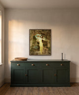 Enchantment by Frantisek Strouhal: woman in a long yellow gown in a stone arch, banded sky and landscape beyond, the 24 by 30 inch print in a dark oak floater frame, hanging above a dark green sideboard in a calm room, shown at its true size