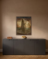 Shangrila by Frantisek Strouhal: robed figure with a staff before a glowing sky and still water, the 24 by 30 inch print in a dark oak floater frame, hanging above a charcoal grey cabinet in a calm room, shown at its true size