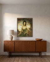 Absorbed in the Moment by Frantisek Strouhal: a woman in a green dress seated in dry grass under a teal sky, the 24 by 30 inch print in a dark oak floater frame, hanging above a walnut sideboard in a calm room, shown at its true size