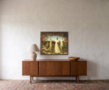 Qui Suis Je? by Frantisek Strouhal: four women in red, gold, cream and green gowns in a field under a dark sky, the 30 by 24 inch print in a dark oak floater frame, hanging above a walnut sideboard in a calm room, shown at its true size