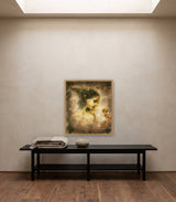 Love Prevails by Frantisek Strouhal: woman in profile holding a pale yellow flower, soft brown and rose haze, the 24 by 30 inch print in a pale oak floater frame, hanging above a black painted bench in a calm room, shown at its true size