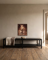 Aurora by Frantisek Strouhal: a woman lying at the water's edge with trees and a shaft of light behind, the 16 by 20 inch print in a dark oak floater frame, hanging above a black painted bench in a calm room, shown at its true size