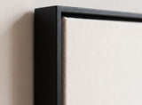 The corner of the black painted floater frame, with the shadow gap that runs all the way round between the canvas and the wood.