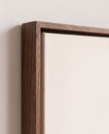 The corner of the dark oak floater frame, with the shadow gap that runs all the way round between the canvas and the wood.