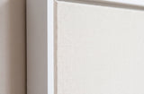 The corner of the white painted floater frame, with the shadow gap that runs all the way round between the canvas and the wood.