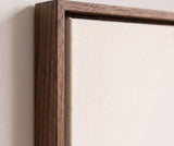 The corner of the dark oak floater frame, with the shadow gap that runs all the way round between the canvas and the wood.