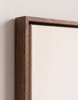 The corner of the dark oak floater frame, with the shadow gap that runs all the way round between the canvas and the wood.