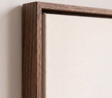 The corner of the dark oak floater frame, with the shadow gap that runs all the way round between the canvas and the wood.