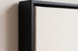 The corner of the black painted floater frame, with the shadow gap that runs all the way round between the canvas and the wood.