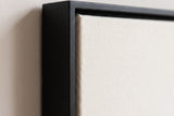 The corner of the black painted floater frame, with the shadow gap that runs all the way round between the canvas and the wood.