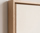 The corner of the pale oak floater frame, with the shadow gap that runs all the way round between the canvas and the wood.