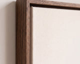 The corner of the dark oak floater frame, with the shadow gap that runs all the way round between the canvas and the wood.