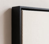 The corner of the black painted floater frame, with the shadow gap that runs all the way round between the canvas and the wood.