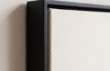 The corner of the black painted floater frame, with the shadow gap that runs all the way round between the canvas and the wood.
