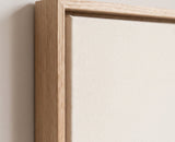 The corner of the pale oak floater frame, with the shadow gap that runs all the way round between the canvas and the wood.