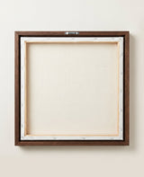The back of the framed canvas: the canvas stretched over light wooden bars and stapled around the inner edge, one sawtooth hanger fitted to the top bar, and no bracing across the middle. The frame edge is dark oak.
