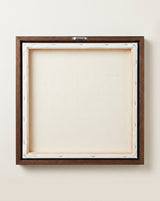 The back of the framed canvas: the canvas stretched over light wooden bars and stapled around the inner edge, one sawtooth hanger fitted to the top bar, and no bracing across the middle. The frame edge is dark oak.