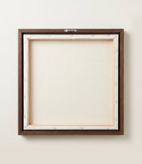 The back of the framed canvas: the canvas stretched over light wooden bars and stapled around the inner edge, one sawtooth hanger fitted to the top bar, and no bracing across the middle. The frame edge is dark oak.