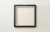 The back of the framed canvas: the canvas stretched over light wooden bars and stapled around the inner edge, one sawtooth hanger fitted to the top bar, and no bracing across the middle. The frame edge is black painted.