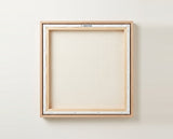 The back of the framed canvas: the canvas stretched over light wooden bars and stapled around the inner edge, one sawtooth hanger fitted to the top bar, and no bracing across the middle. The frame edge is pale oak.
