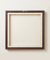 The back of the framed canvas: the canvas stretched over light wooden bars and stapled around the inner edge, one sawtooth hanger fitted to the top bar, and no bracing across the middle. The frame edge is dark oak.