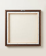 The back of the framed canvas: the canvas stretched over light wooden bars and stapled around the inner edge, one sawtooth hanger fitted to the top bar, and no bracing across the middle. The frame edge is dark oak.