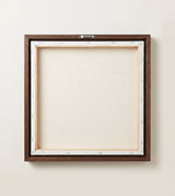 The back of the framed canvas: the canvas stretched over light wooden bars and stapled around the inner edge, one sawtooth hanger fitted to the top bar, and no bracing across the middle. The frame edge is dark oak.