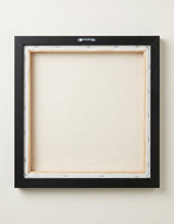 The back of the framed canvas: the canvas stretched over light wooden bars and stapled around the inner edge, one sawtooth hanger fitted to the top bar, and no bracing across the middle. The frame edge is black painted.