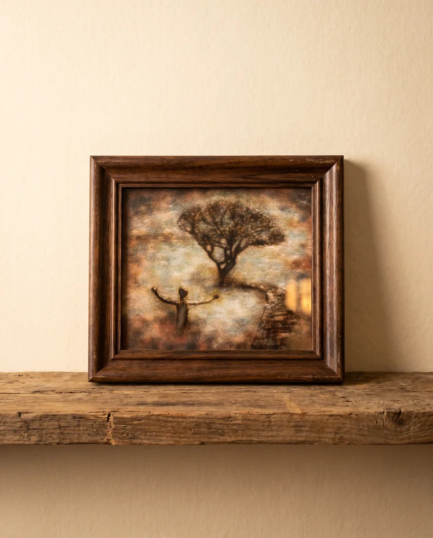 The Tree of Life in a walnut frame resting on a wooden shelf